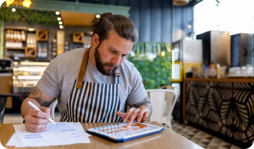 A café owner reviewing paperwork and business finances at a table